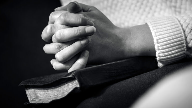 Close up of person with bible praying