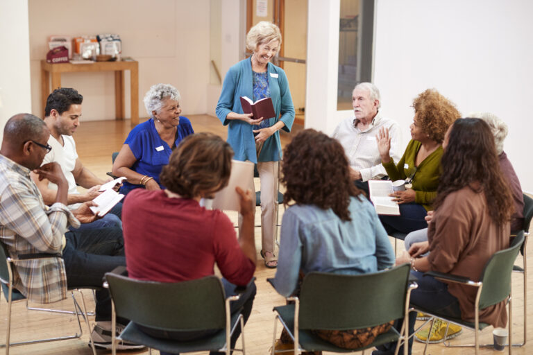 People Attending Bible Study Group Meeting In Community